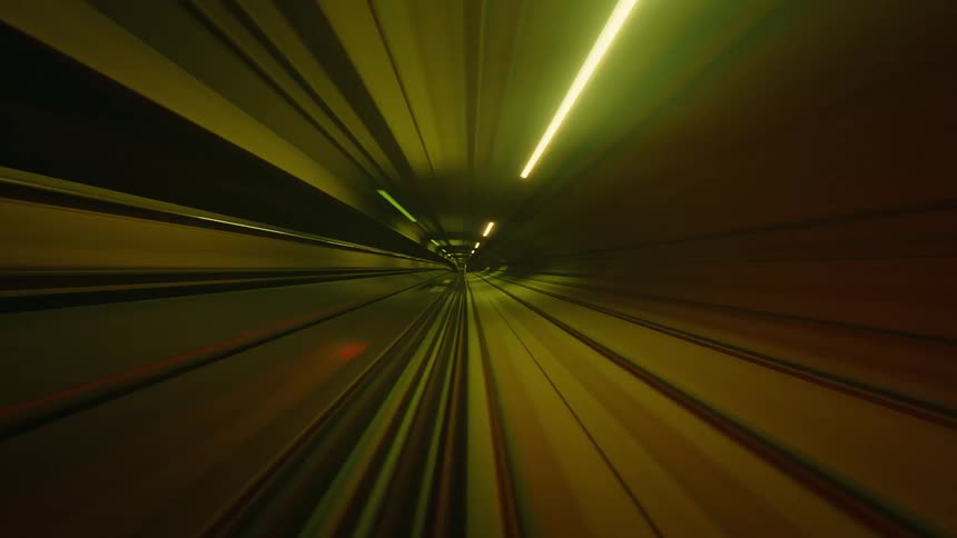 An abstract and surreal POV timelapse of a train speeding through a neon-lit tunnel, creating vibrant light streaks