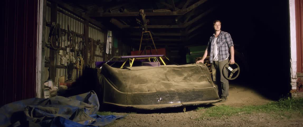 A man stands near a demolished vehicle