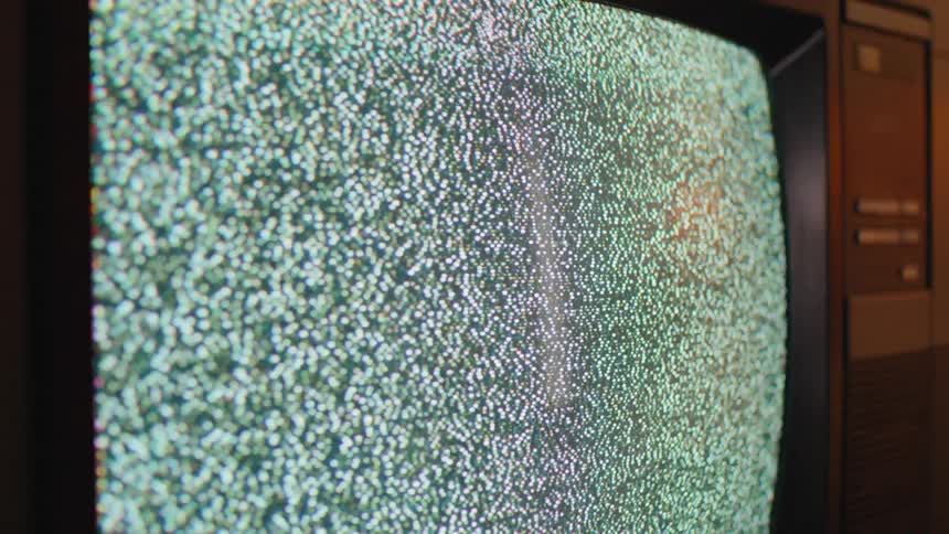 Static on a vintage television screen is abruptly turned off, leaving a blank, dark screen