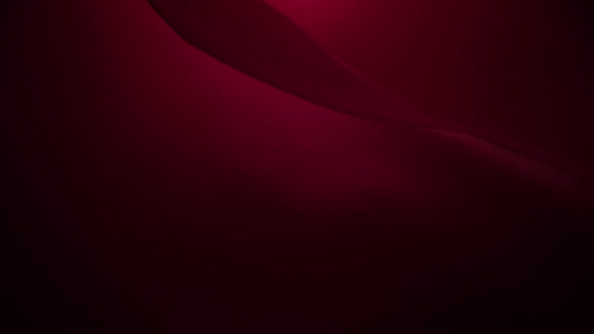 An elegant and smooth burgundy fabric undulates gently in a seamless looping animation