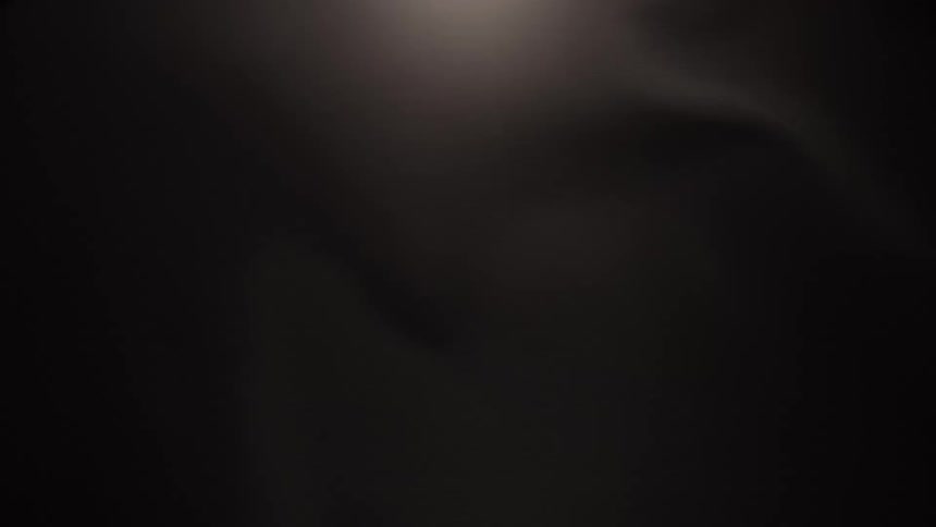Dark, silky, abstract waves flow gracefully in slow motion against a black background