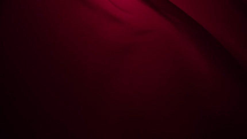 A sophisticated abstract background of deep red silk fabric moving in slow, elegant waves