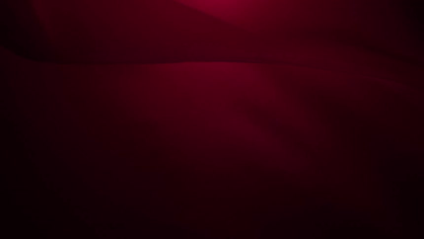 Soft, flowing waves of deep red light create a smooth and elegant abstract background animation
