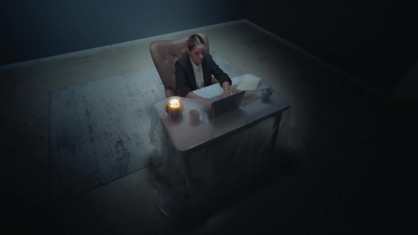 An anxious businesswoman works through the night in a dark, isolated office, showing signs of stress and burnout in a time-lapse