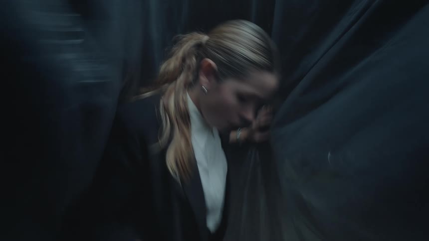A disoriented woman experiences a panic attack, feeling trapped and falling in a dark, claustrophobic space