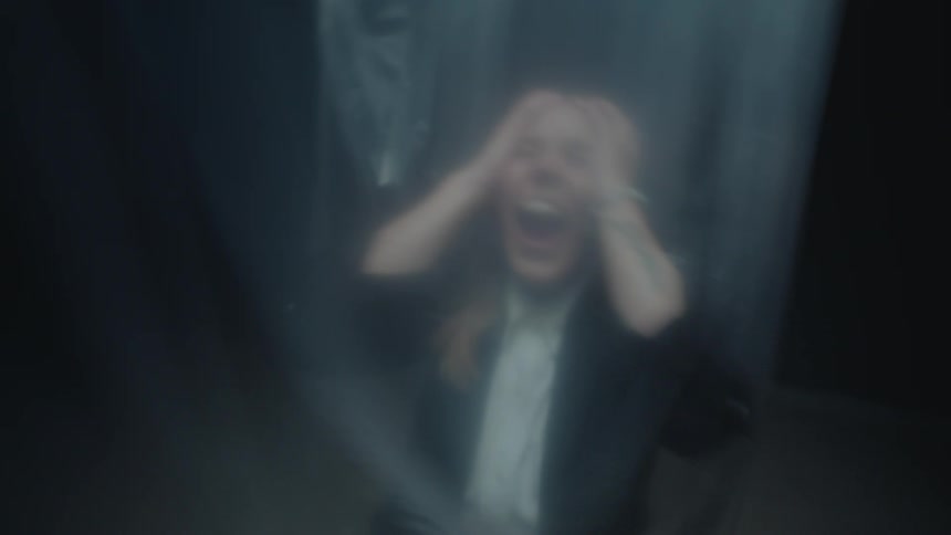 A blurry and distressed person screams in horror and fear while trapped behind a translucent plastic sheet