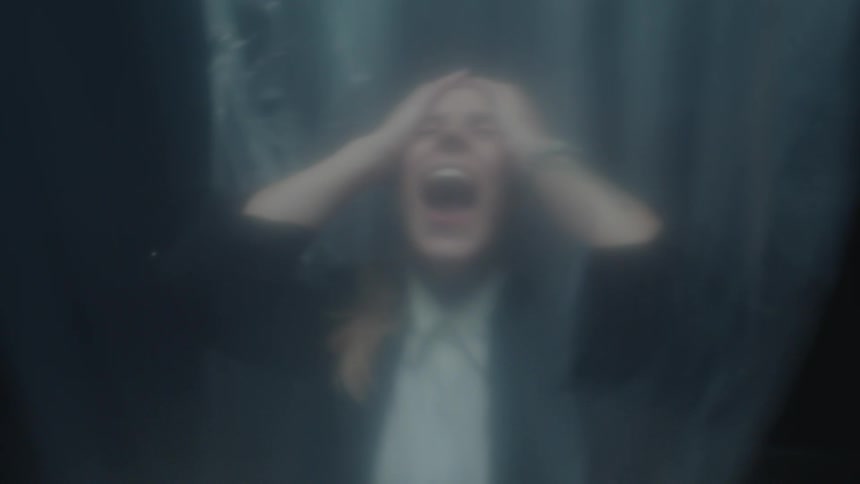A terrified businesswoman screams in desperation while trapped behind a translucent plastic sheet in a dark, confined space