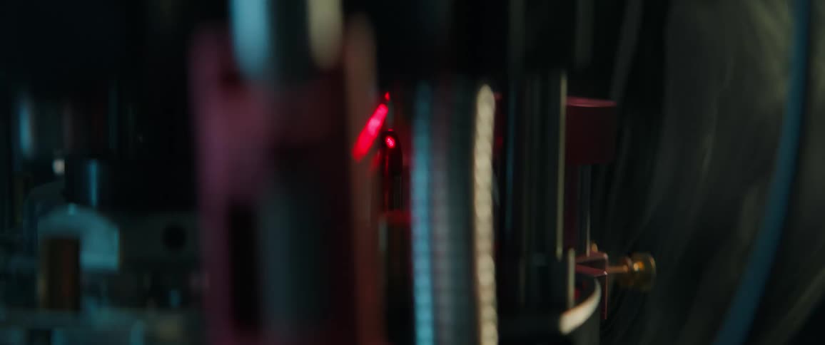 High-tech automated machinery uses a precision red laser to scan bullets on an assembly line for quality control