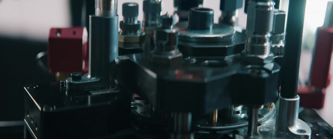 A detailed close-up shot captures the intricate process of an automated reloading press manufacturing ammunition