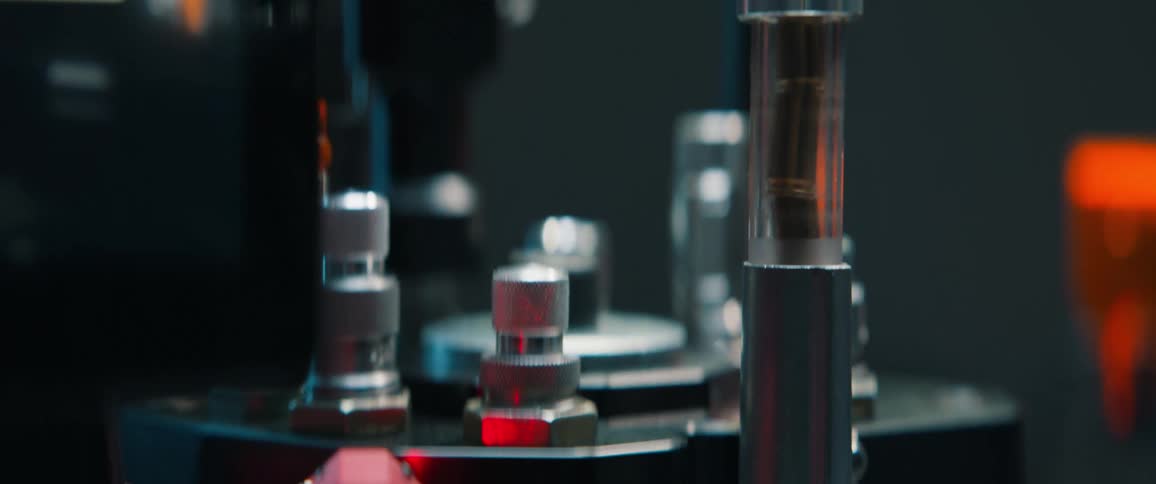 A worker operates a touchscreen to control an automated ammunition press, which then assembles bullets that fall into a collection bin