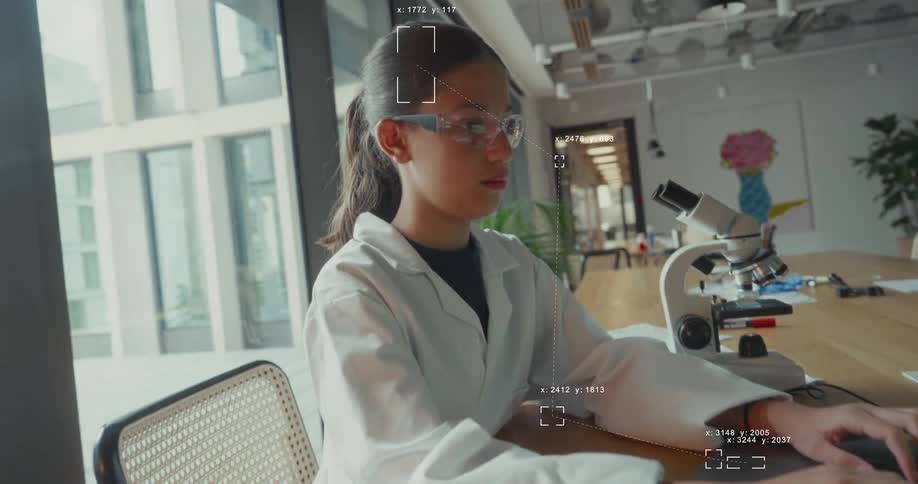 A young female scientist in a lab coat and augmented reality glasses works on a laptop with data graphics overlaying the image