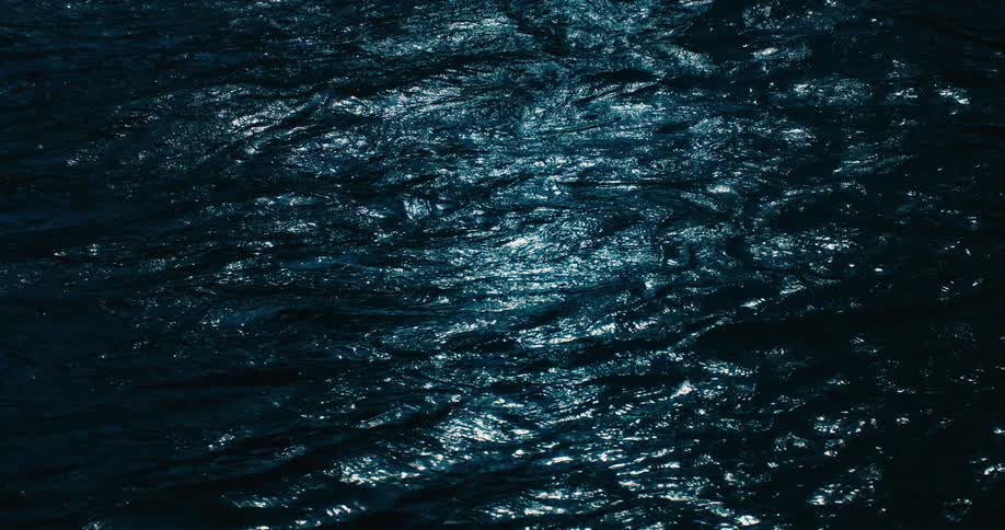 A close-up view of dark, mesmerizing water with shimmering light reflections
