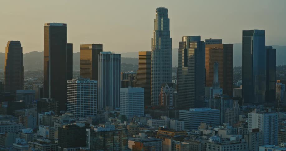 A dramatic time-lapse reveals the majestic downtown Los Angeles skyline as the golden hour sun casts long shadows