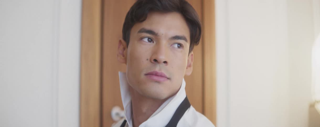 A handsome and contemplative groom looks off-camera as he gets ready for his wedding day