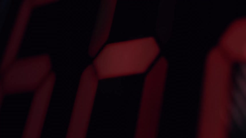 A blurry, extreme close-up shot of a red digital display flickering in the dark