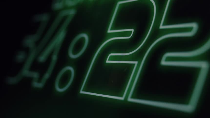 Close-up of a glowing green digital countdown timer rapidly moving through the seconds