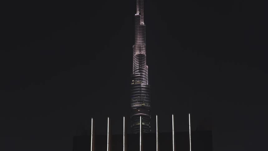 Dramatic aerial reveal of the Burj Khalifa and the glittering Dubai skyline at night