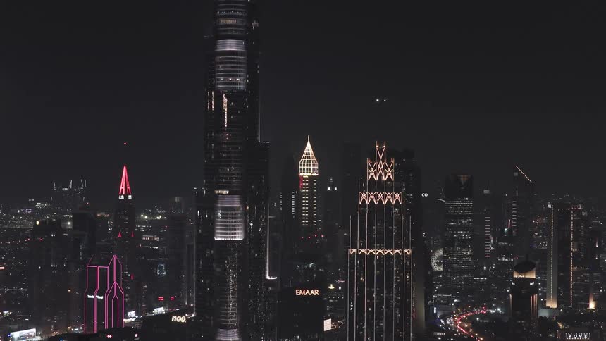 A stunning aerial view zooms out to reveal the dazzling illuminated skyline of downtown Dubai at night