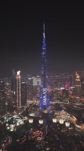 A stunning aerial view of the Burj Khalifa in Dubai illuminated by a spectacular light show at night