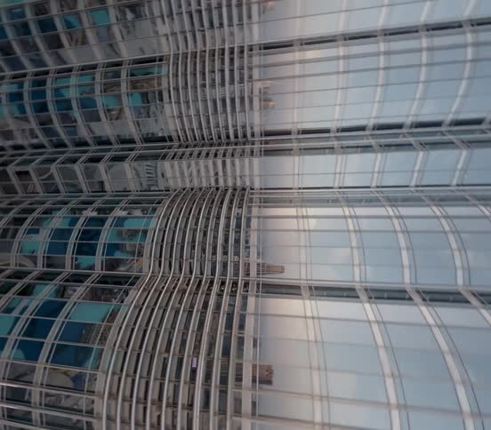 A dizzying first-person perspective shot looking straight down the reflective glass facade of the Burj Khalifa skyscraper in Dubai