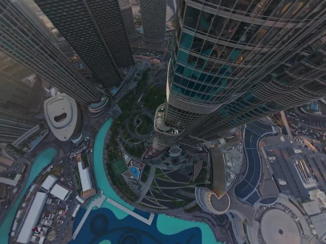 A dizzying 360-degree aerial view descends down the Burj Khalifa, revealing the Dubai cityscape and fountains below