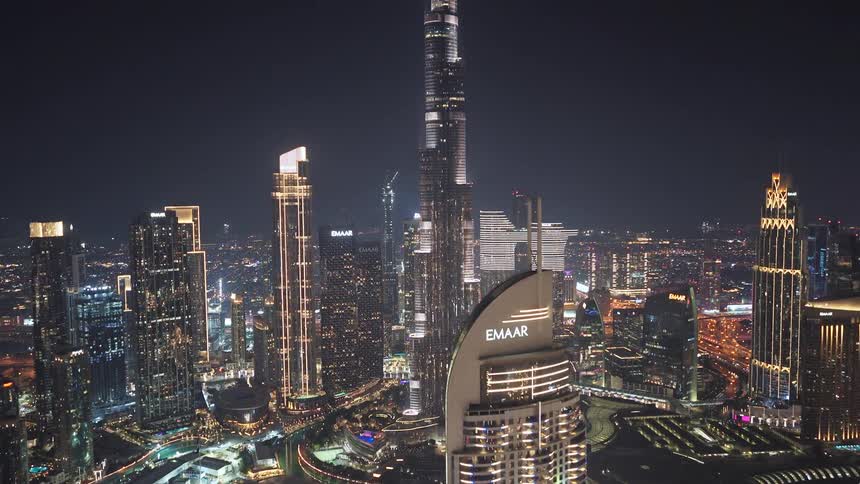Cinematic aerial reveal of the dazzling Dubai skyline at night, culminating in a spectacular view of the iconic Burj Khalifa