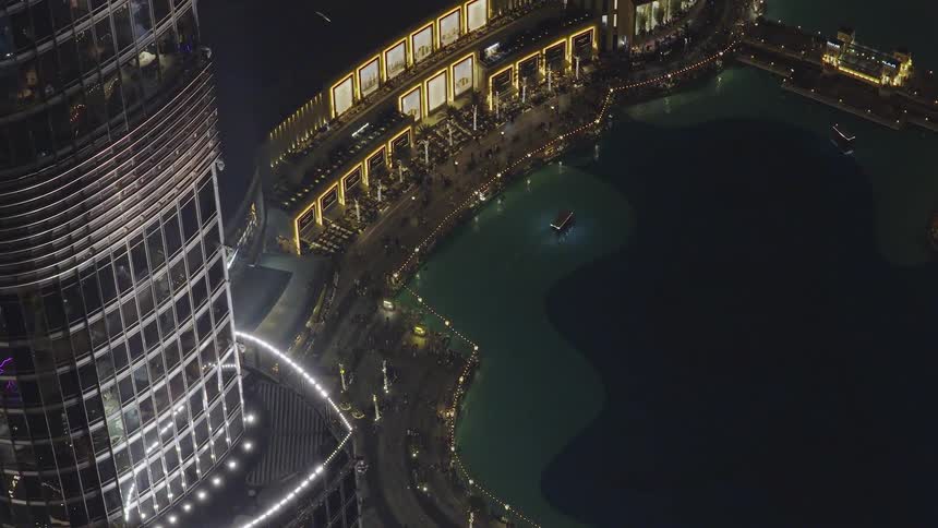 Stunning high-angle aerial view of the Burj Khalifa overlooking the illuminated Dubai Mall and fountain lake at night