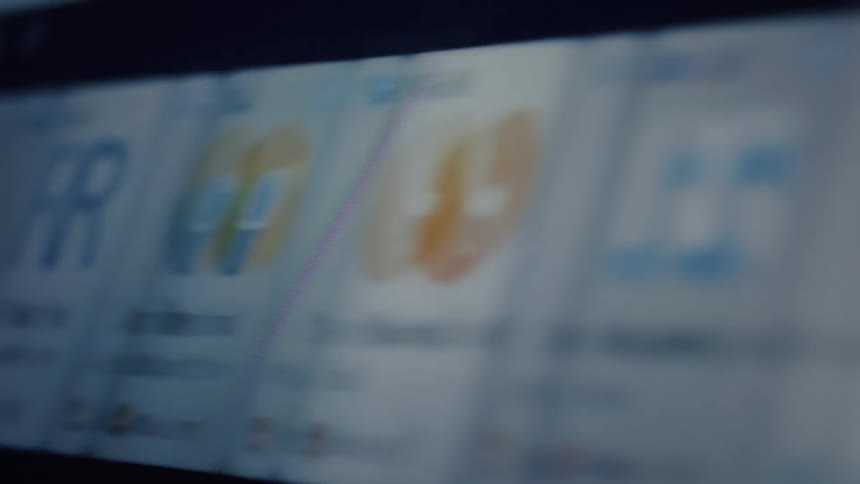 A close-up, blurry shot pans across a digital screen filled with a grid of colorful app icons