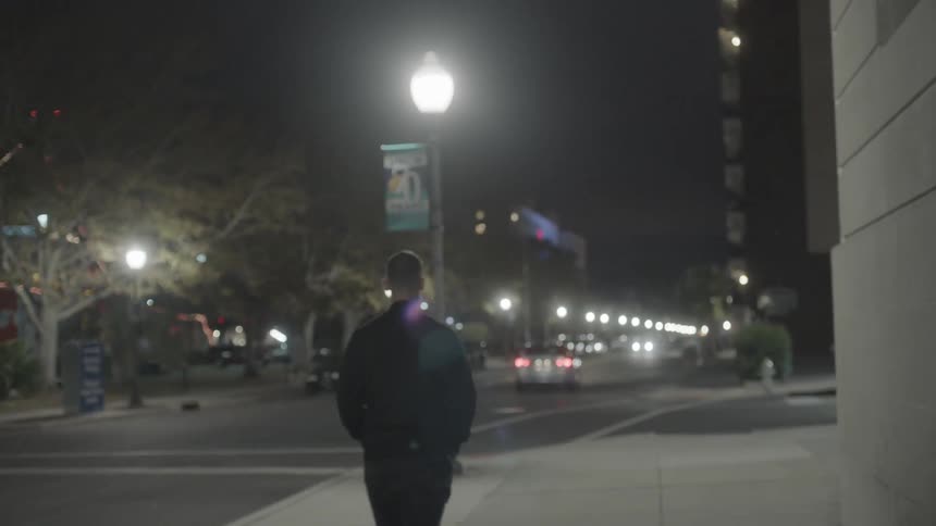 Man walking down a city street at night