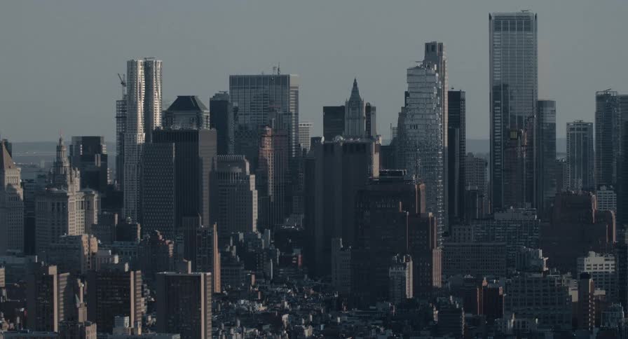 A static, wide shot of the Lower Manhattan skyline as seen from a high angle on an overcast day
