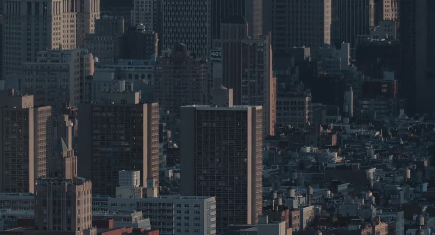 A time-lapse captures the morning light moving across the dense architecture of a bustling city