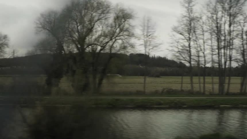 Moving past a long field on a cloudy day