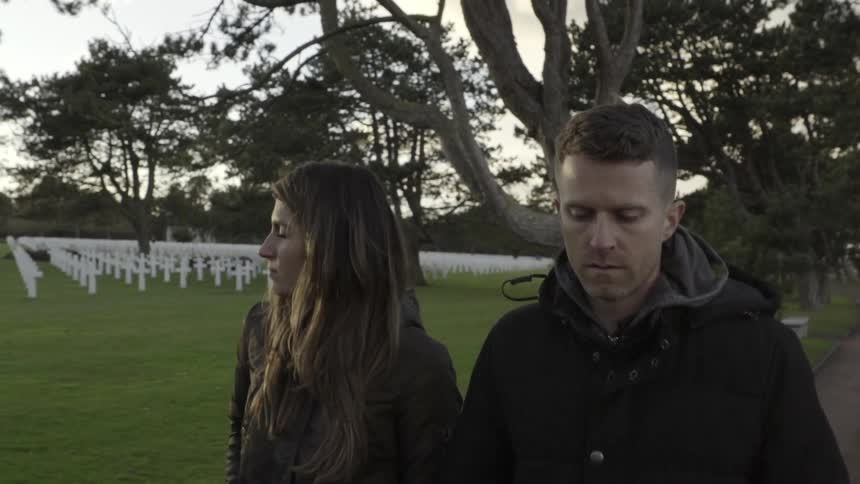A man and woman walk through a cemetery