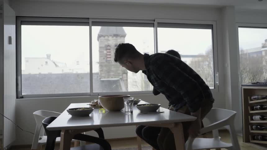 Man and woman sit down to eat a meal together