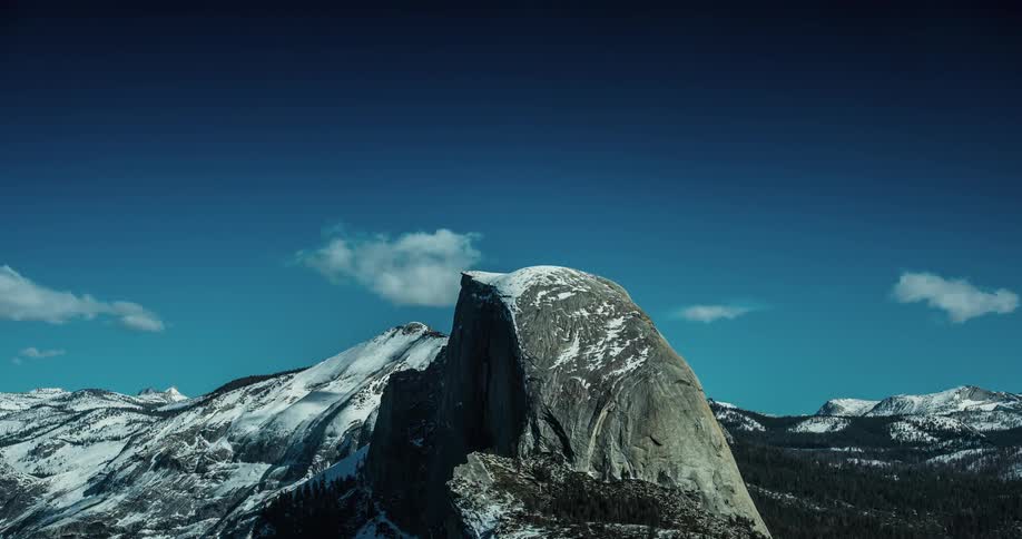 Time-lapse of clouds moving over snowy mountains