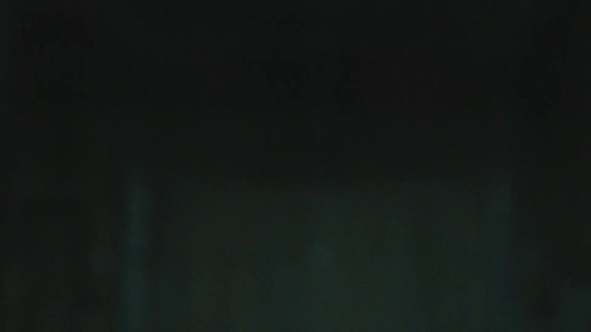 A pane of glass shatters in dramatic slow motion, sending shards flying through a dark space