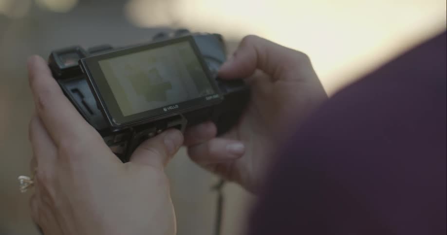 A photographer reviews photos on her camera