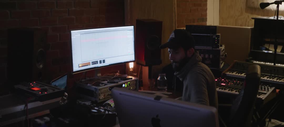 A man is listening to music in a studio working