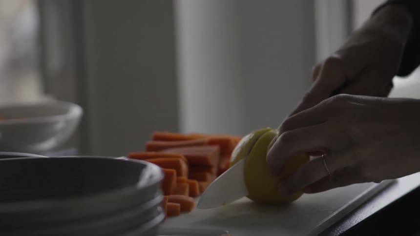 A person is cutting an onion