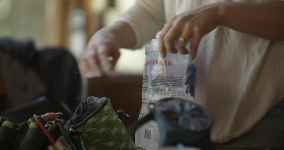 A woman unpacks items from a bag into another