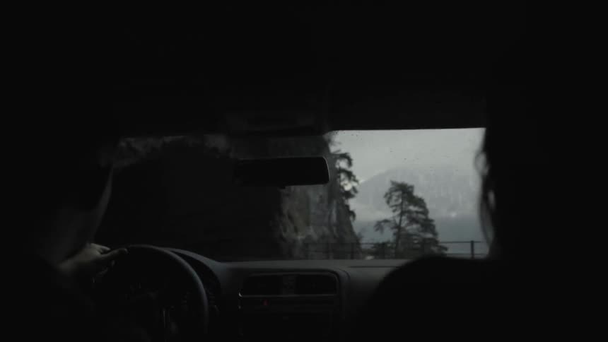 People drive there car out of and into a tunnel on a rainy day