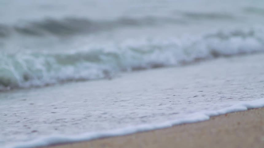The waves crash on the sand