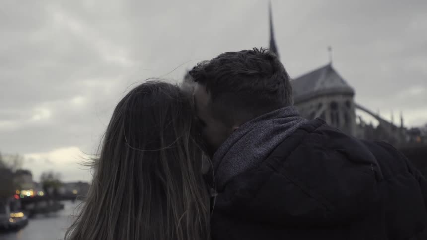 A man leans over to a woman kissing her