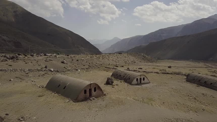 The field has some barracks before a mountain