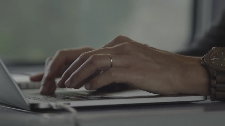 Close up of a person's hands typing on a laptop