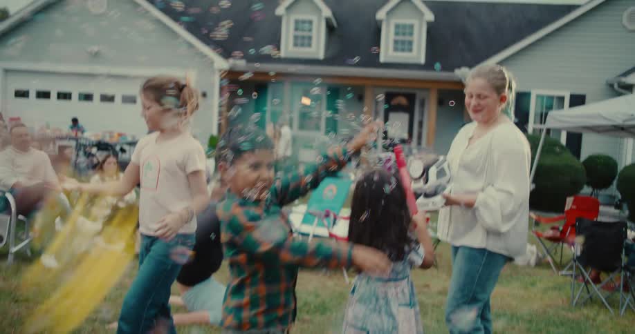 Joyful children dance and play in a flurry of bubbles during a neighborhood backyard party