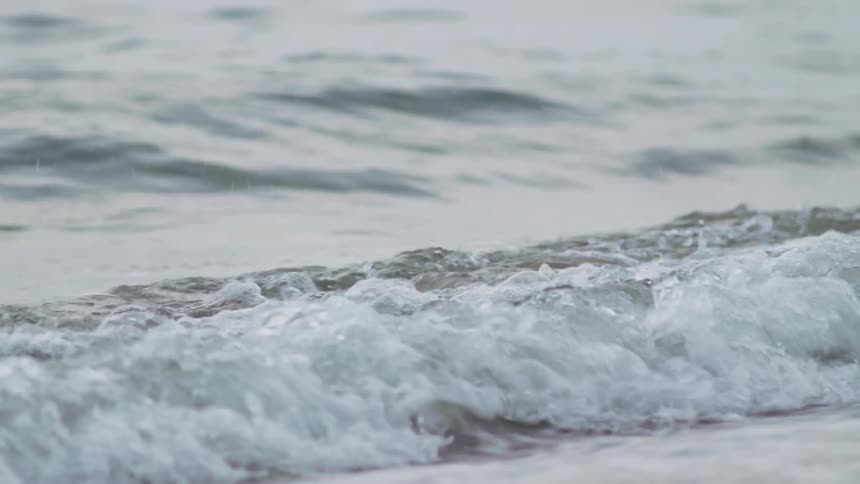 A waves crests and rolls onto the shore