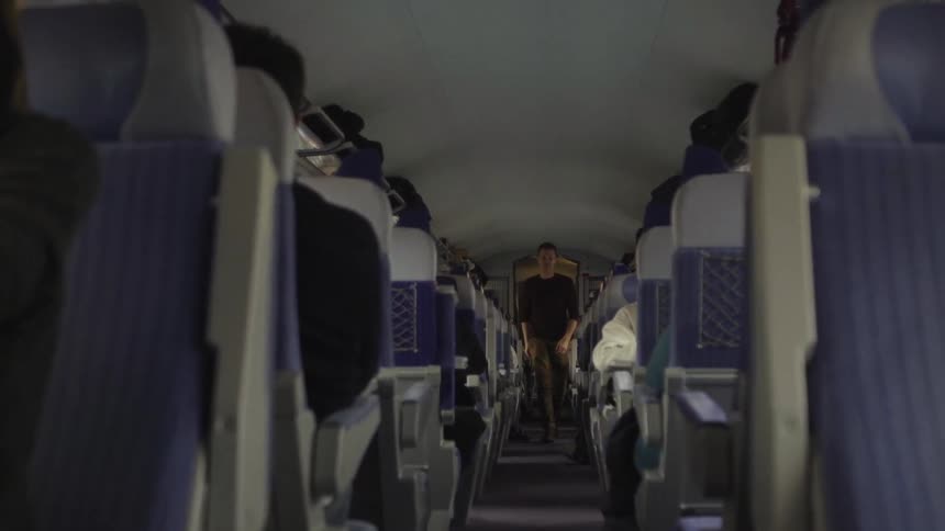 A man walks down the aisle of a plane