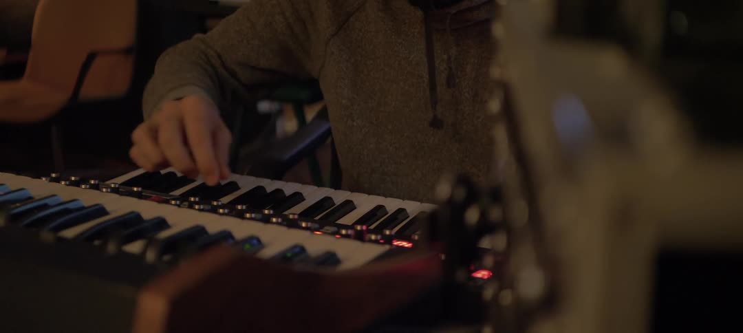 A man is turning dials on his keyboard