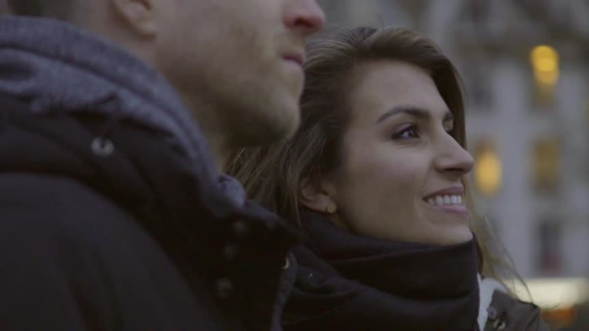 A woman laughs and talks with a man outside